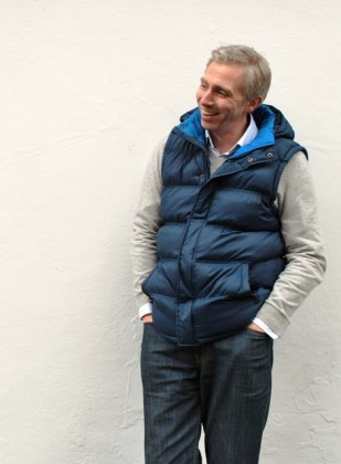 J standing against white wall